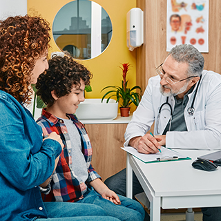 Pediatrician talking with parent and child