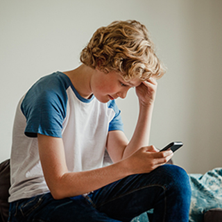 Young boy looking at his phone