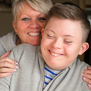 Mother hugging her son from behind.