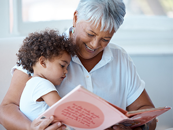 grandmother reading book to toddler