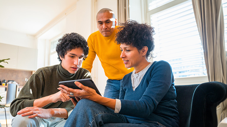 mother, father and teenager doing research on a tablet