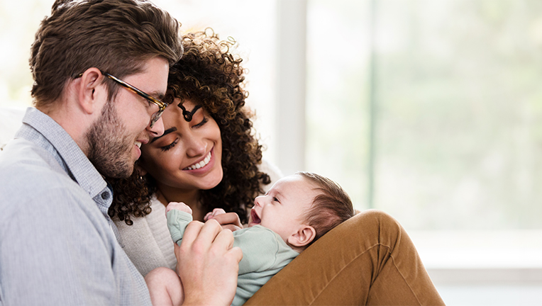 New parents with a newborn enjoying a moment.