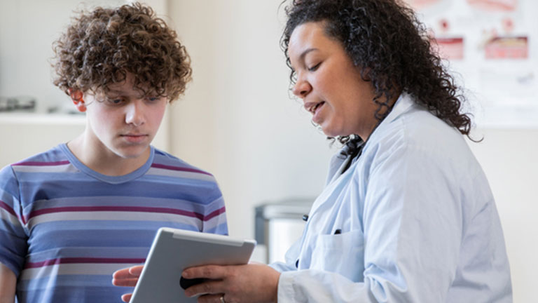 Teenager consulting with doctor